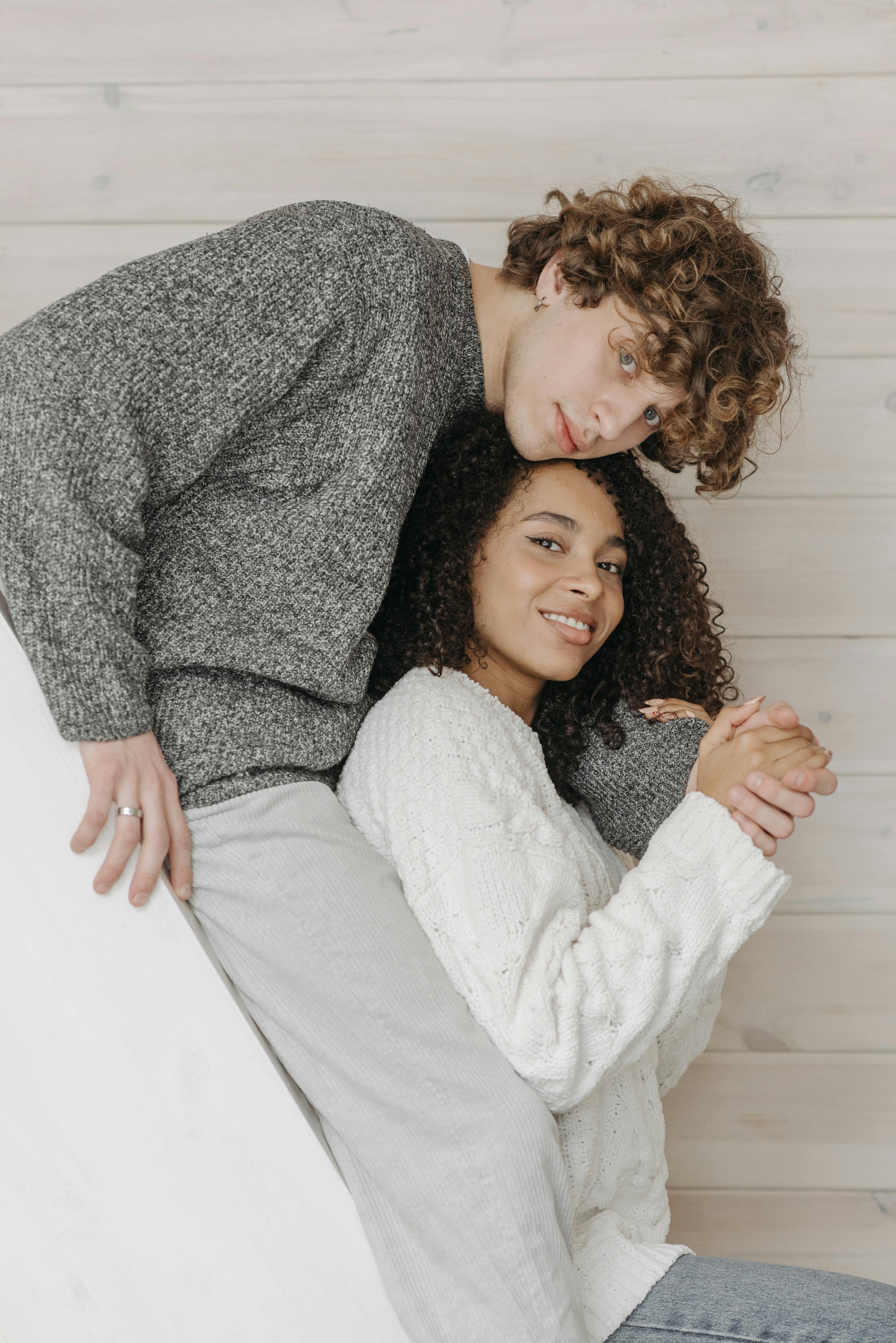 Couple in cozy knit sweaters embracing