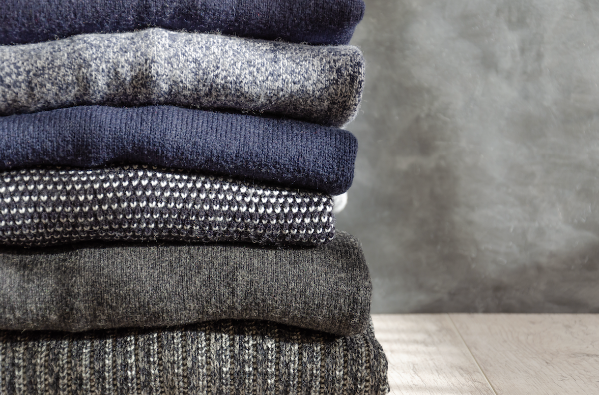 Stacked knitwear in various colors and textures showcasing private label manufacturing quality